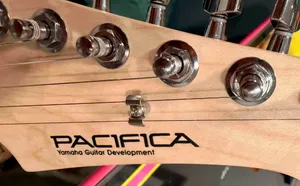 Guitar head with one poorly wrapped string.